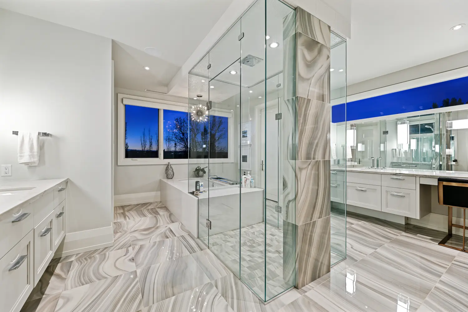 The primary ensuite with a glass-walled steam shower clad in agate-swirl porcelain, a quartz soaker tub beneath a twilight window, floating vanities and a sputnik chandelier over book-matched marbled floors.