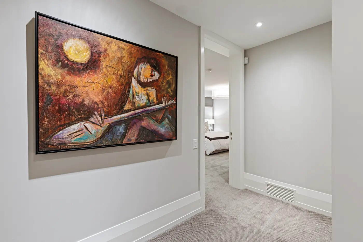 A gallery moment in the lower-level hall, where a large moonlit lute-player canvas leads toward a softly lit guest bedroom.